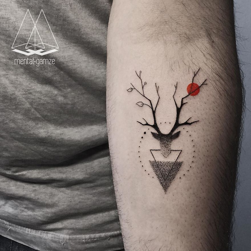 Tattoo artist's work: a geometric deer design with a red dot on an arm.