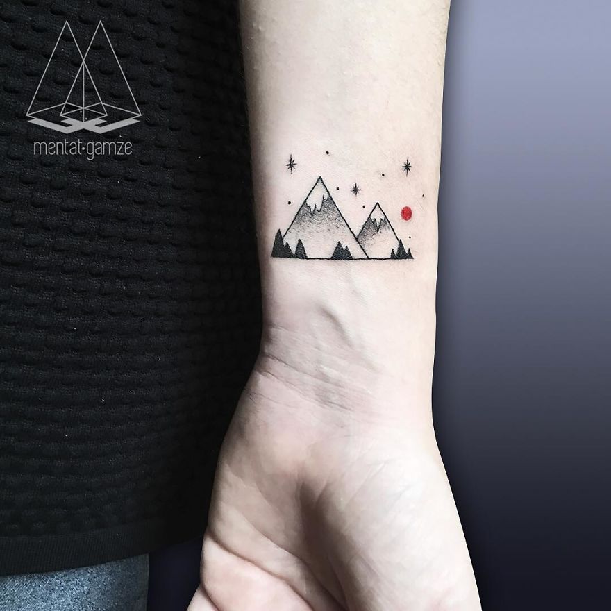 Minimalist mountain tattoo with a red dot on a forearm, symbolizing a career change to tattoo art.