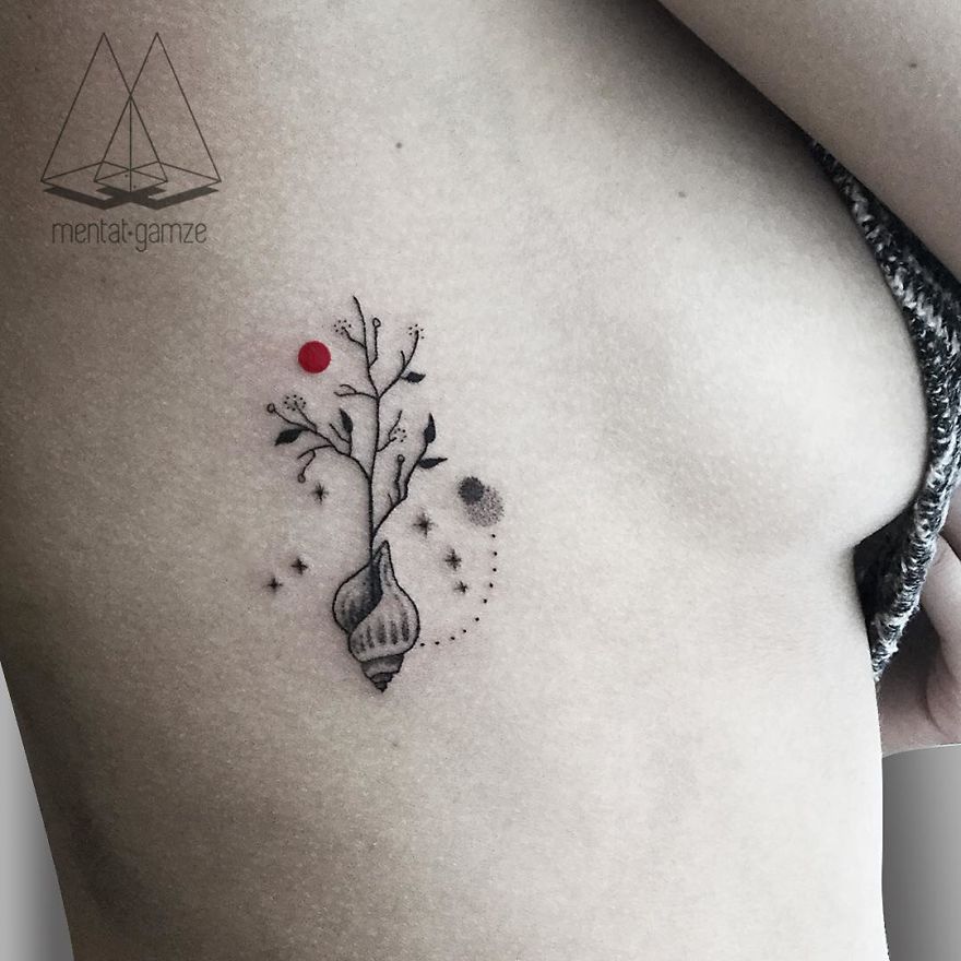 A tattoo of a plant with a red dot and geometric design on the side of a person's torso.