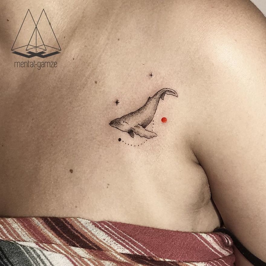 Tattoo of a whale with a red dot on skin, showcasing new tattoo artist skills.