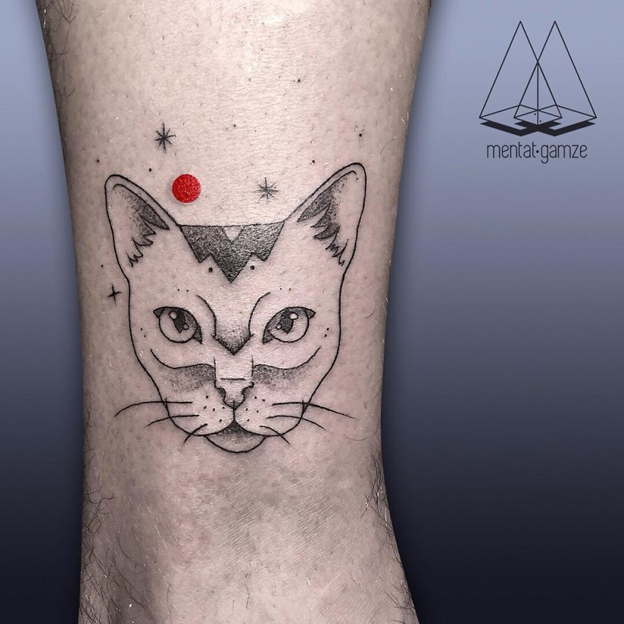 Tattoo of a cat with a red dot above its head on forearm, showcasing artist's career shift to tattooing.