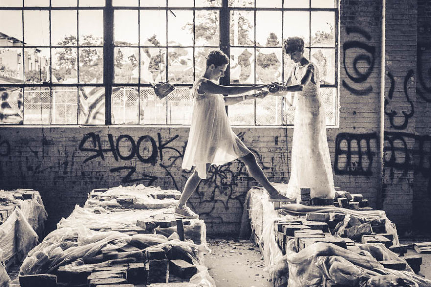 Two woman in dresses walking in abandoned building 