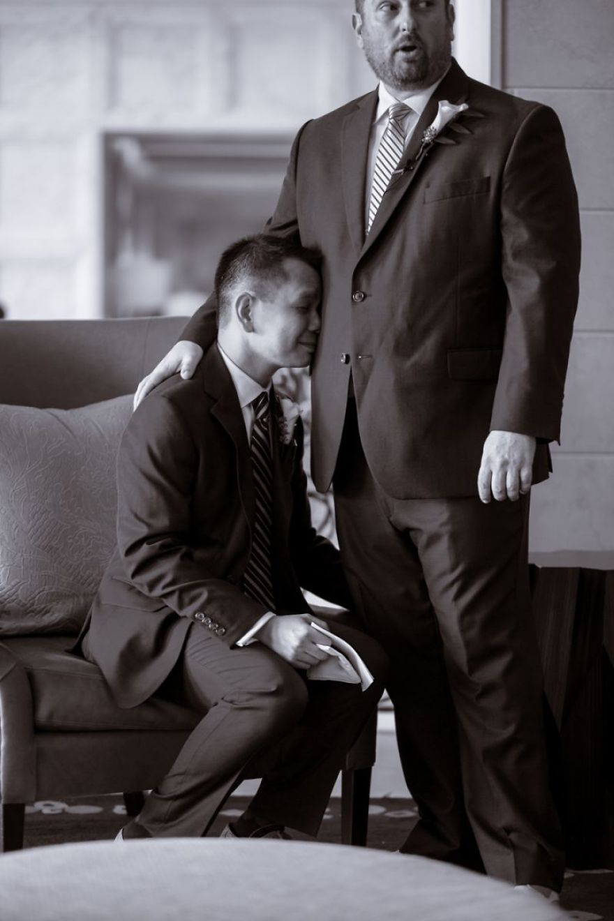 Man standing and other crying o his lap 