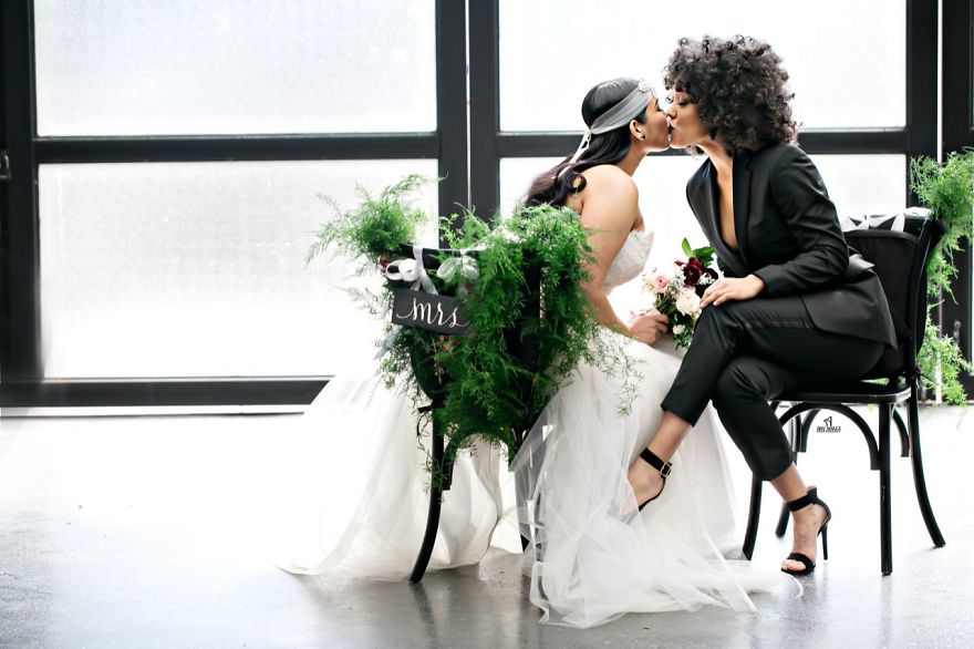 Two woman kissing while sitting 