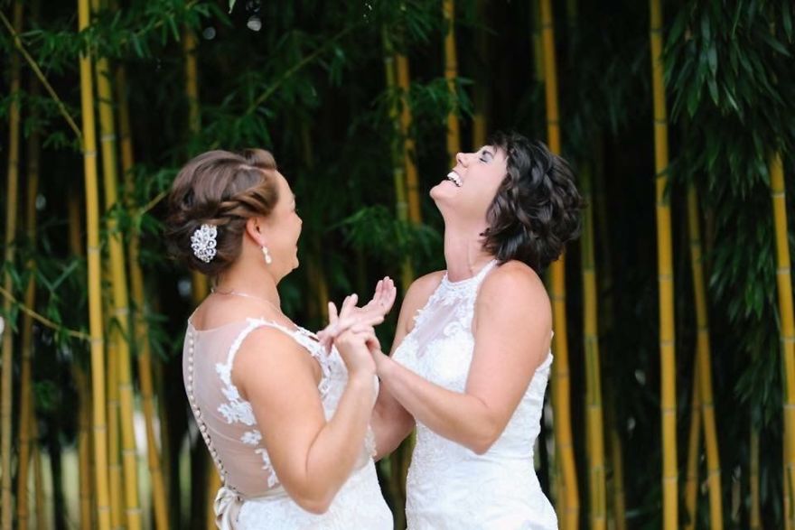 Two happy women holding hands and looking up 