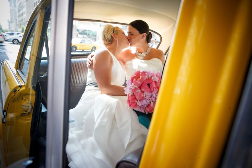 Two women kissing in the car's backseat 