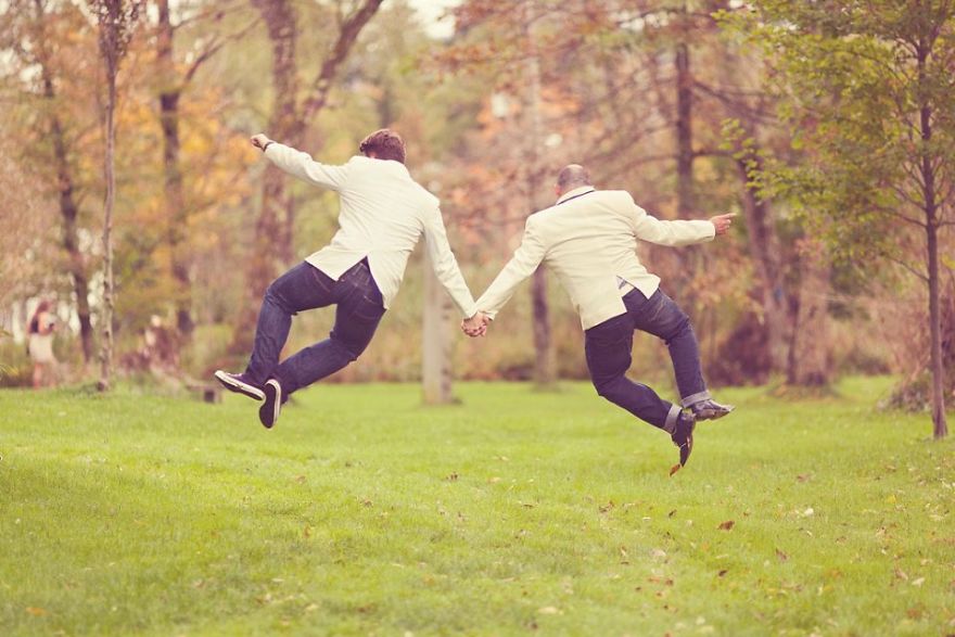 Two man holding hands and jumping 