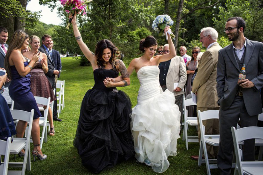 Two woman one in black other in white dress walking 