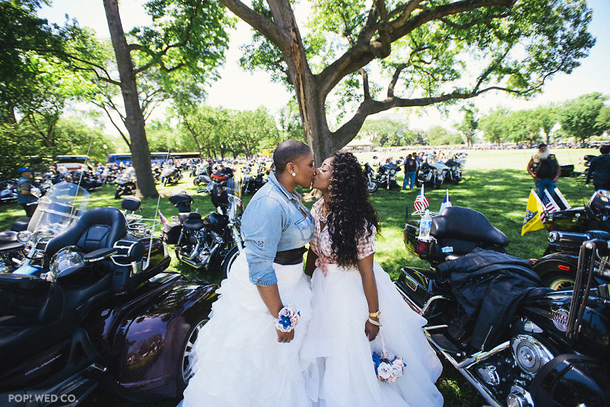 Two happy woman kissing surrounded by motorcycles 