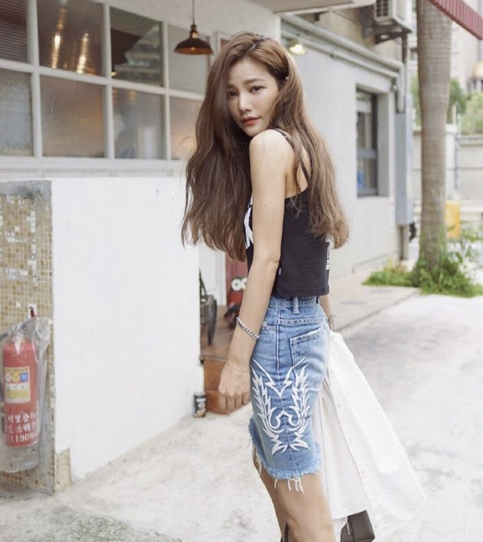 A woman demonstrating age-defying secrets, wearing a black top and denim skirt, with a youthful appearance. A woman demonstrating age-defying secrets, wearing a black top and denim skirt, with a youthful appearance.