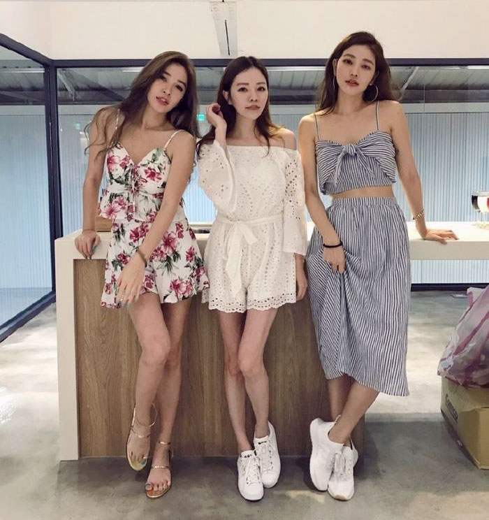 Three young women standing indoors, showcasing age-defying style and confidence. Three young women standing indoors, showcasing age-defying style and confidence.