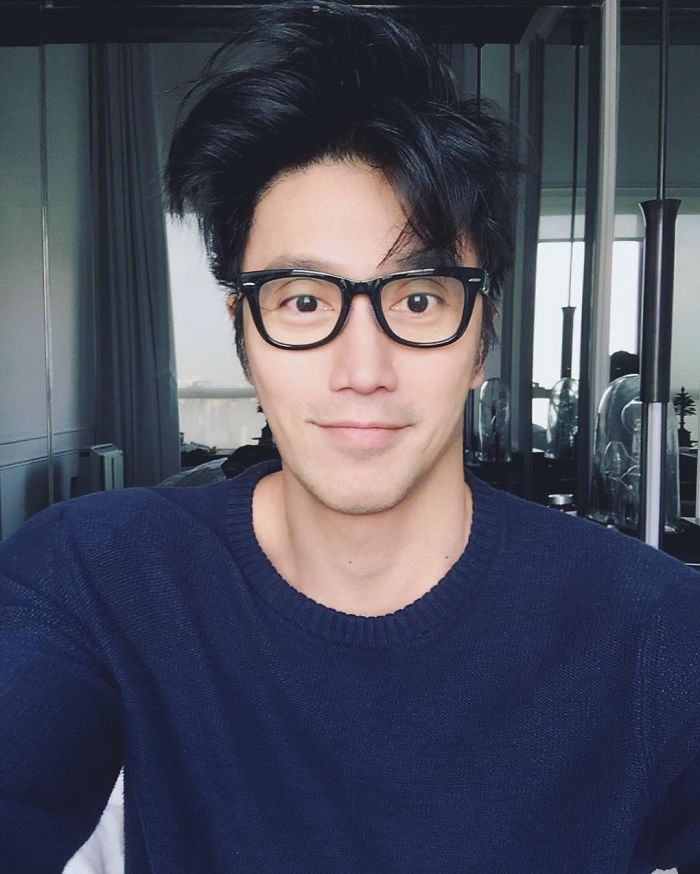 59-year-old man with the body of a 20-year-old wearing glasses and a dark-blue sweater, smiling indoors. 59-year-old man with the body of a 20-year-old wearing glasses and a dark-blue sweater, smiling indoors.