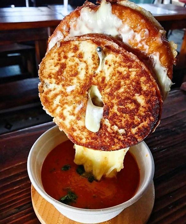 Grilled Cheese Suspended On Metal Hook Above Bowl Of Soup