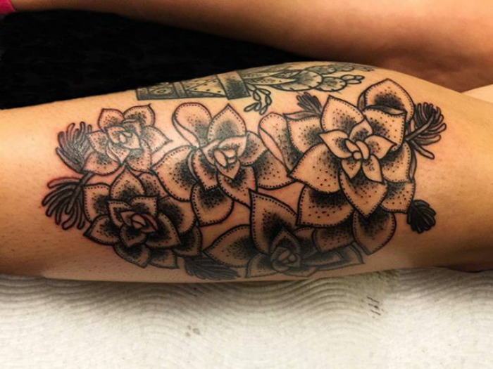 Detailed succulent tattoo design on a person's leg.