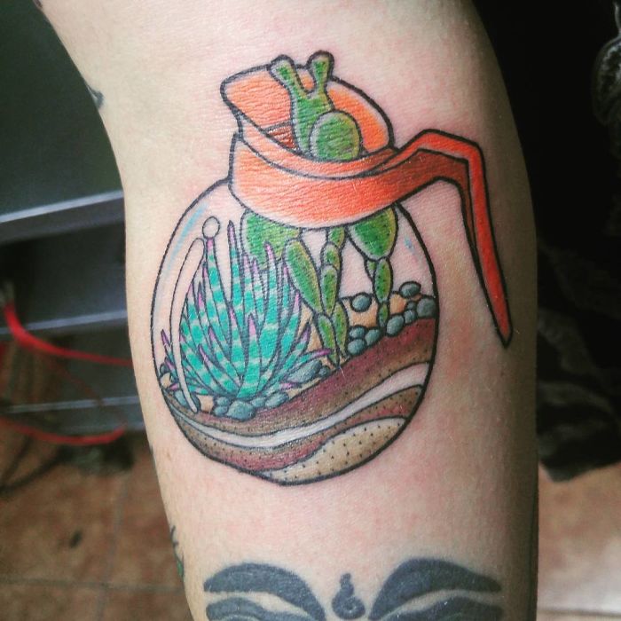 Succulent tattoo featuring vibrant plants inside a terrarium design on forearm.