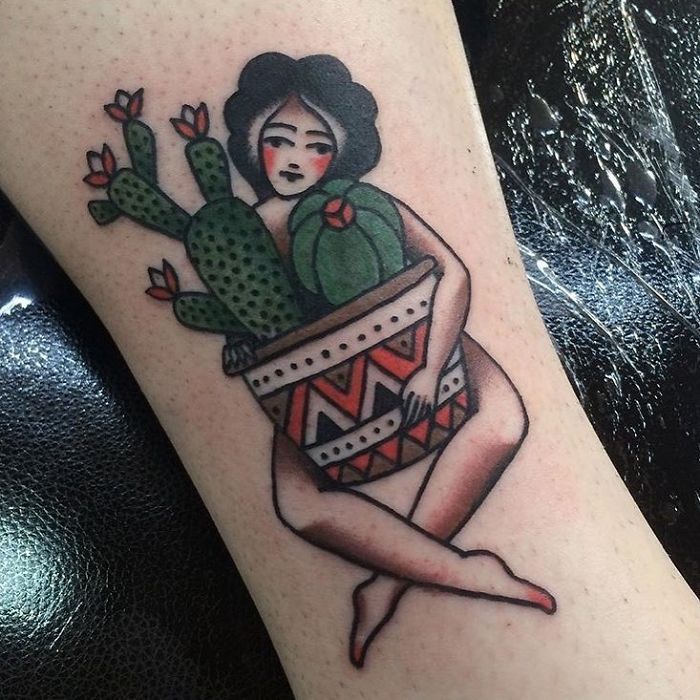 Tattoo of a person holding a colorful pot with succulents.