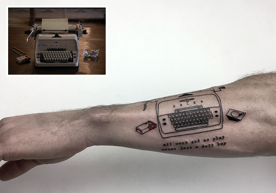Forearm with a typewriter tattoo, featuring "all work and no play" phrase, highlighting dedication to tattooing.