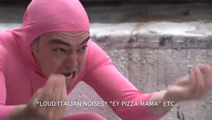 Man wearing pink costume showing italian gesture