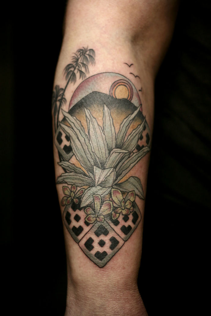 Succulent tattoo featuring a potted plant with mountains and a sunset in the background.