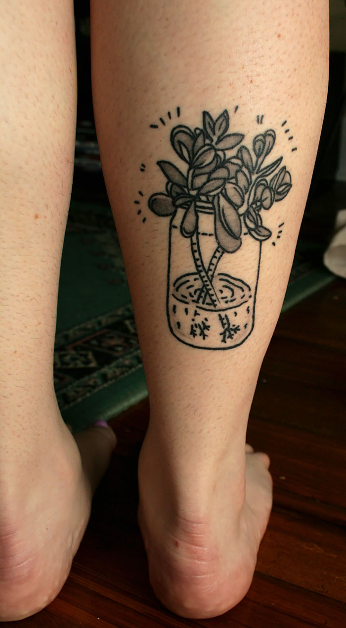 Succulent tattoo on a leg, featuring a plant in a jar, showcasing love for succulents.