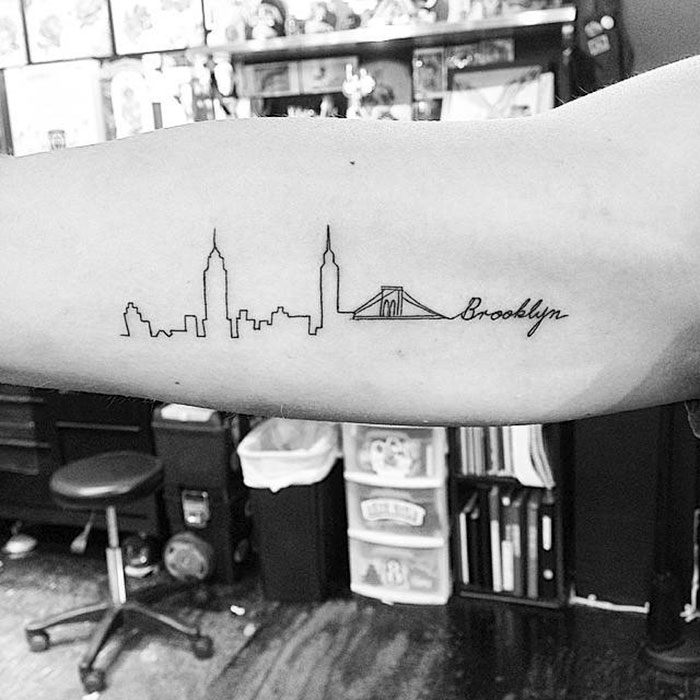 Arm tattoo featuring Brooklyn skyline, showcasing architecture-inspired ink design.