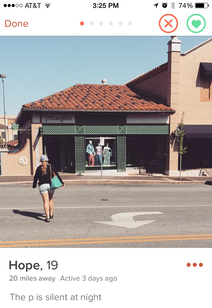 Funny Tinder profile with a pun: "The p is silent at night," in front of a clothing store.