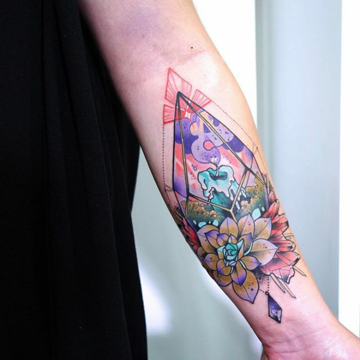 Colorful succulent tattoo on forearm, featuring geometric shapes and a candle, showcasing creative succulent tattoo ideas.