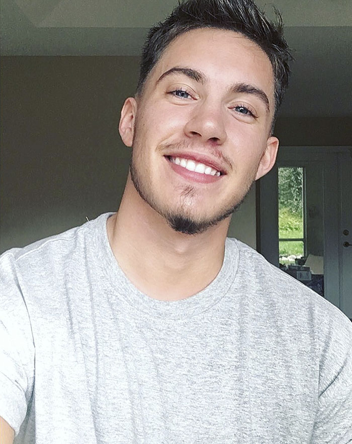 Person smiling in a gray t-shirt, showing a positive expression after transition process. Person smiling in a gray t-shirt, showing a positive expression after transition process.