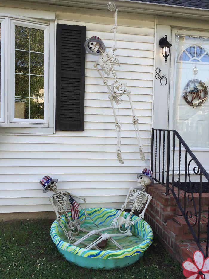 Skeletal decorations in a yard, adding interesting flair to the neighborhood scene.