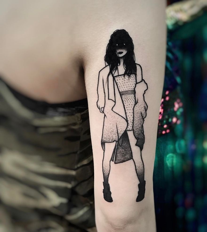 Tattoo of a faceless girl in a stylish outfit on an arm, blending subtle eroticism with artful detail.