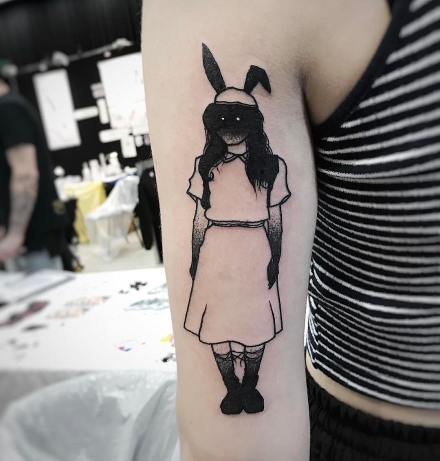 Tattoo of a faceless girl with bunny ears on a person's arm, featuring a slightly erotic and mysterious design.