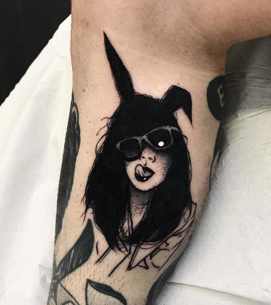 Tattoo of a faceless girl with a bunny hat and sunglasses on an arm.