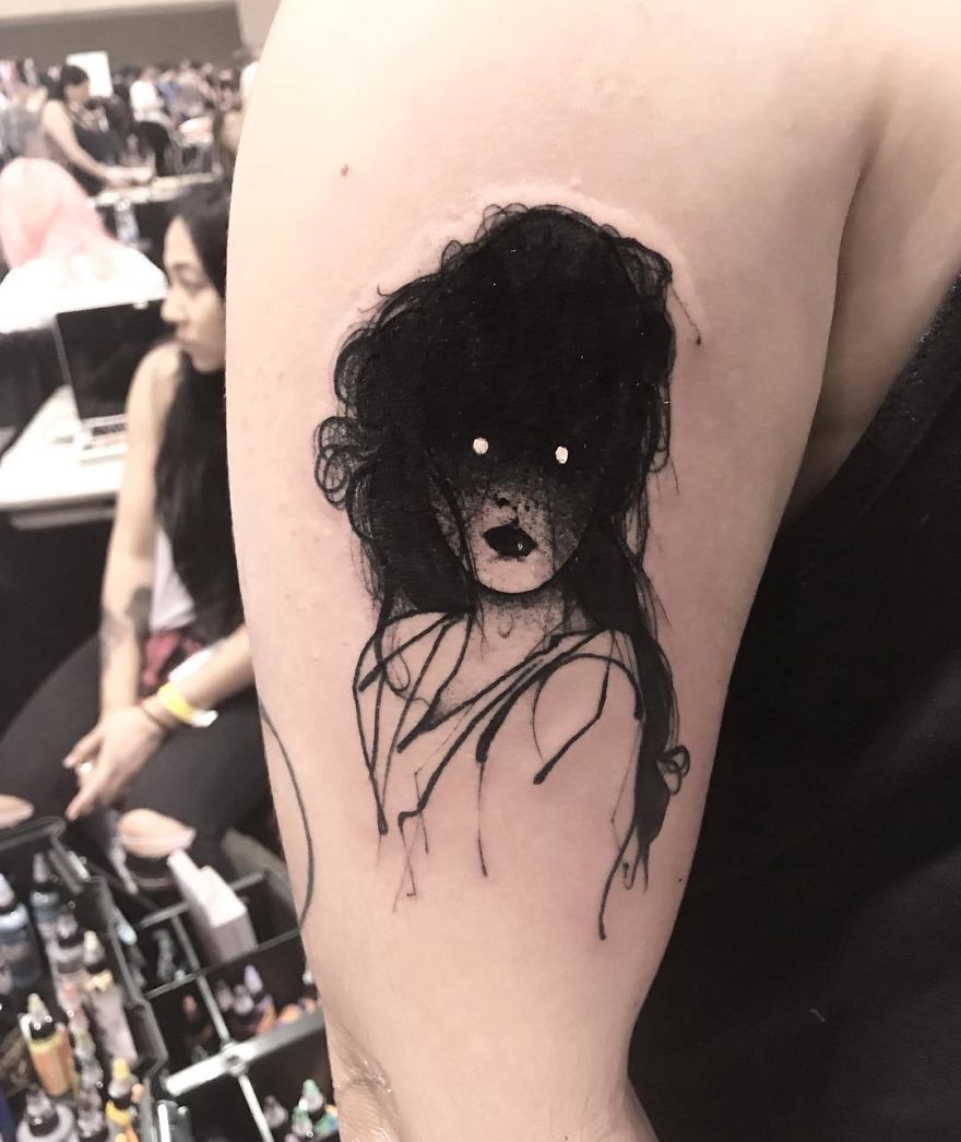 Faceless girl tattoo on arm, featuring abstract, slightly erotic design with dark hair and blank eyes.