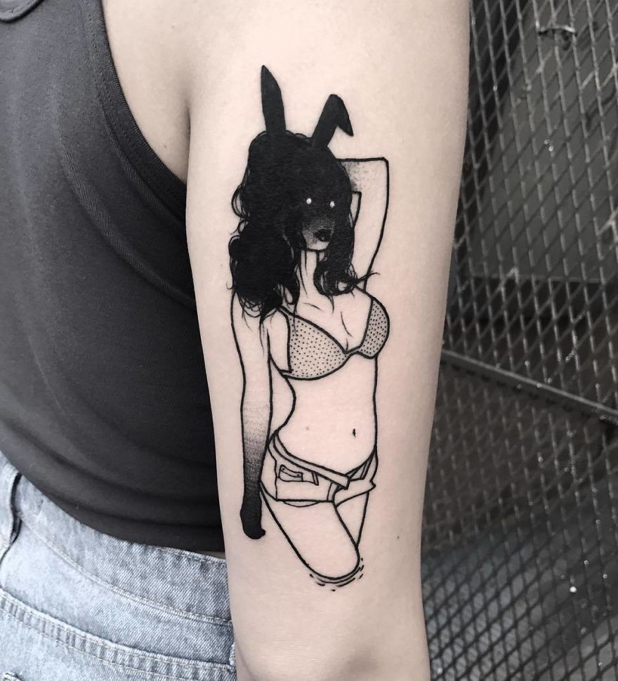 Tattoo of a faceless girl in lingerie with bunny ears on arm.