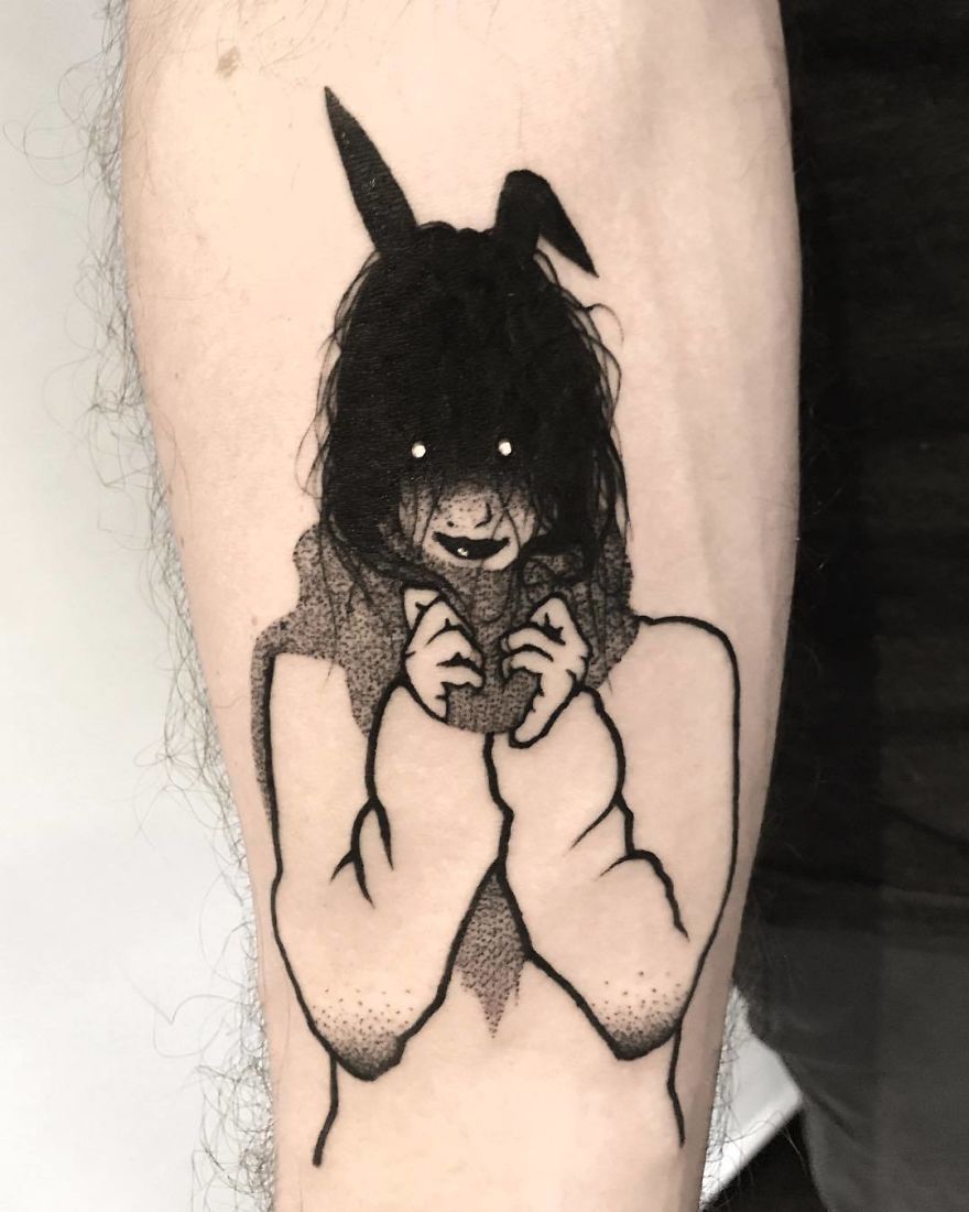 Tattoo of a faceless girl with long hair and bunny ears on a person's arm, showcasing an artistic and slightly erotic style.