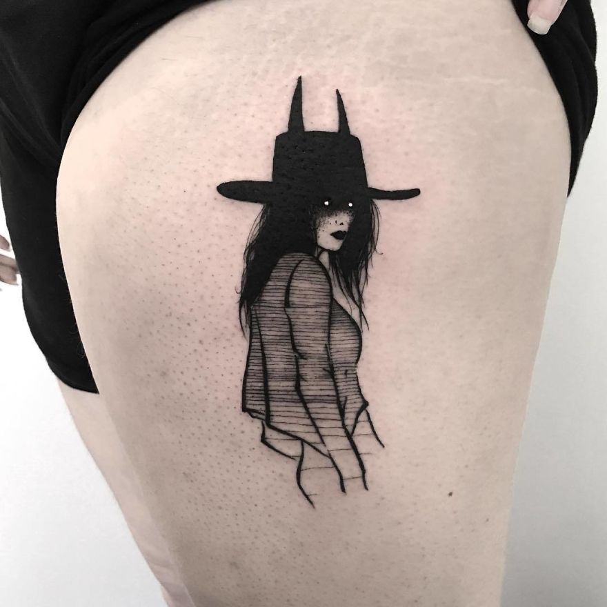 Tattoo of a faceless girl with long hair and a hat on a person's thigh, slightly erotic style.