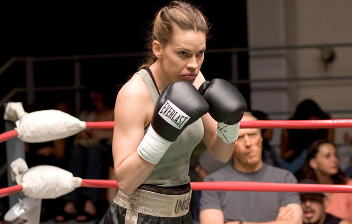 Scene from Million Dollar Baby movie showing a focused female boxer wearing Everlast gloves in the ring for fun facts about movies.