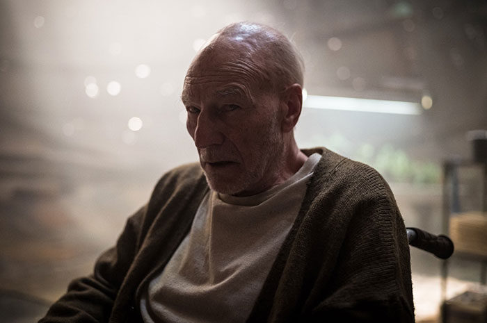 Elderly man in a dark cardigan sitting in a dimly lit room, a scene from the movie Logan, related to fun facts about movies.