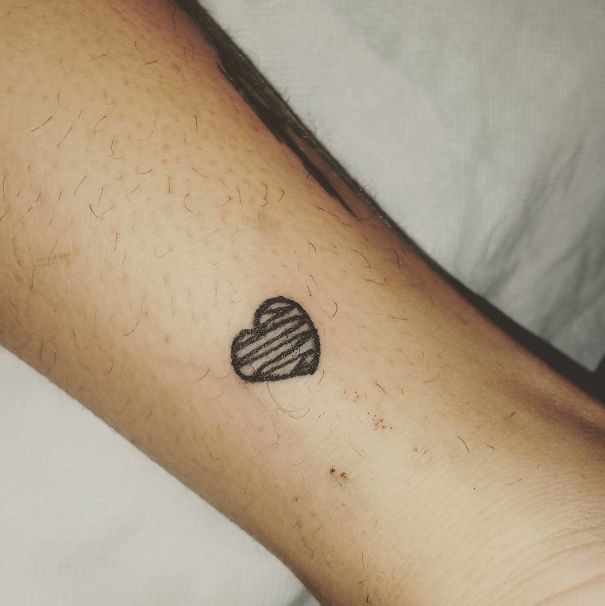 Simple heart tattoo on skin by Brazilian artist, known for her unique and unconventional tattoo style.