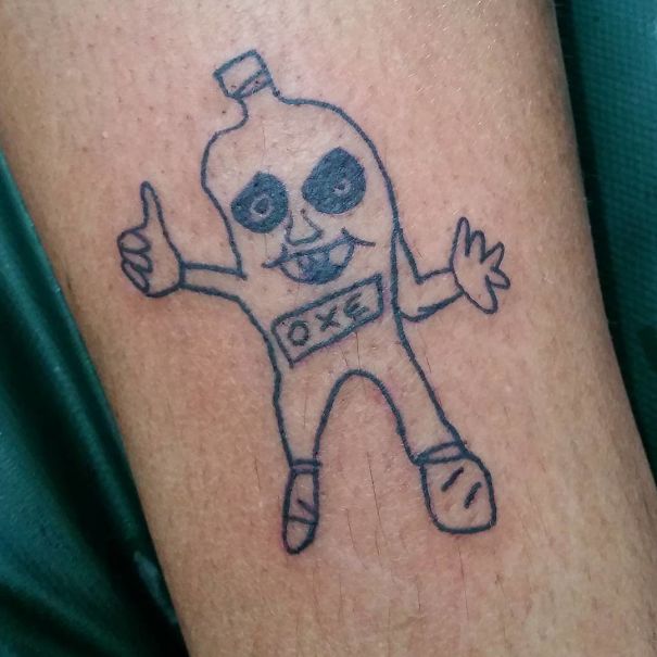 Amateur drawing tattoo on skin by Brazilian tattoo artist, featuring a character with a bottle-shaped head and the word "OXE."