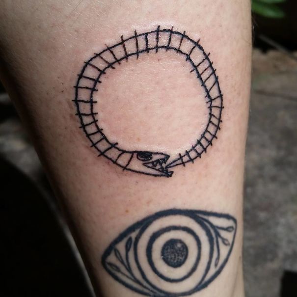 Tattoo of a simple snake circle and abstract eye designed by Brazilian artist.
