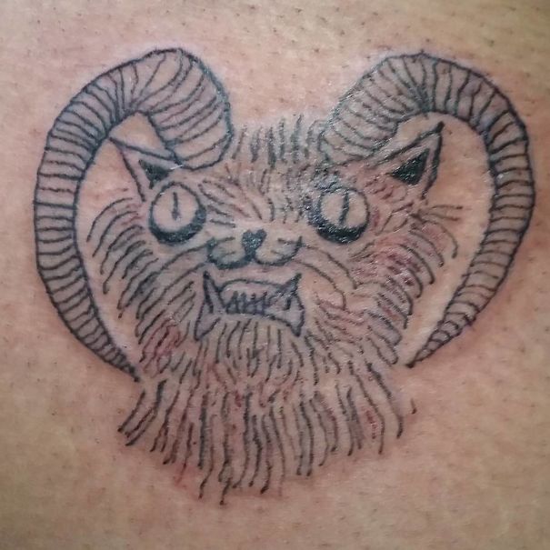 Tattoo of a crudely drawn cat with horns, created by a Brazilian tattoo artist.