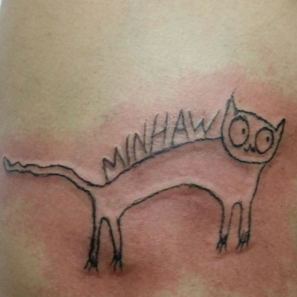Roughly drawn cat tattoo by Brazilian artist, featuring the word "MINHAW" on a person's skin.