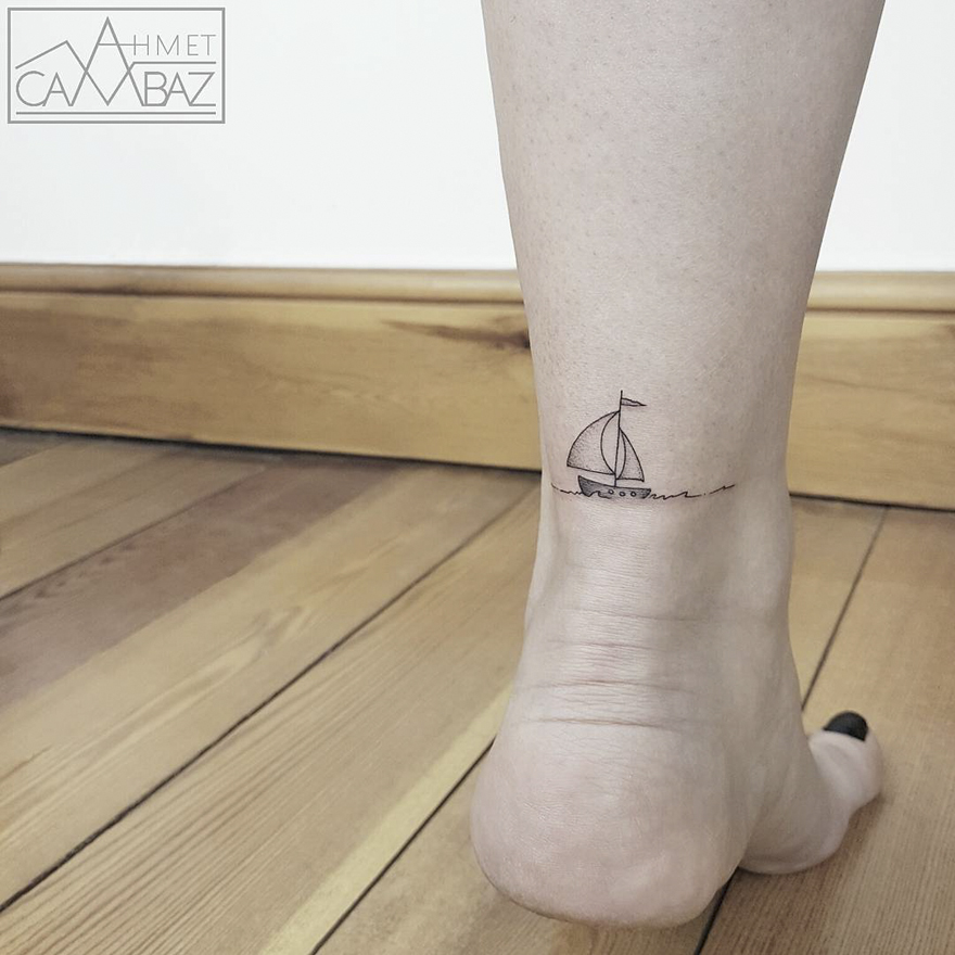 Minimalist sailboat tattoo on ankle by Turkish cartoonist, featuring clean lines and simple design.