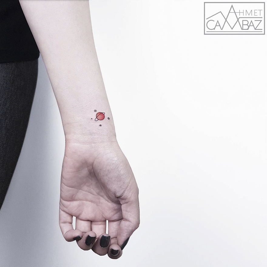Minimalist cartoon tattoo of a red planet on forearm by former Turkish cartoonist.