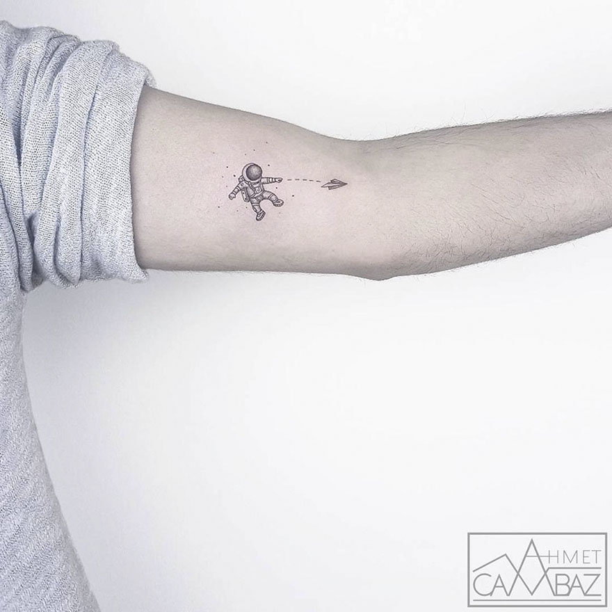 Minimalistic astronaut tattoo on arm by Turkish cartoonist.