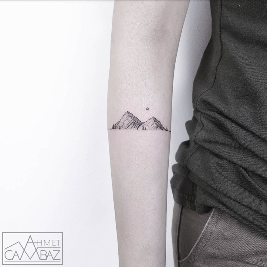 Minimal mountain tattoo by Turkish artist on an arm, showcasing simple yet striking design.