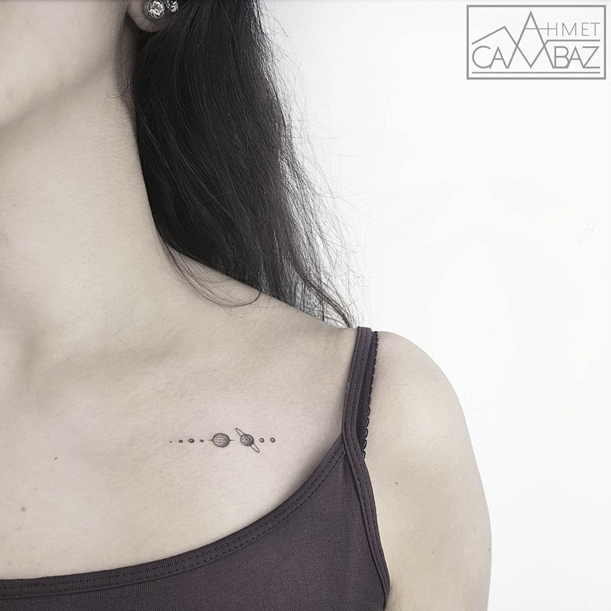 Minimal solar system tattoo on a woman's collarbone by a former Turkish cartoonist.