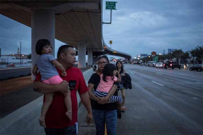 The Duong Family Walks Along Interstate 45 While Escaping Flood Waters In Houston, Texas