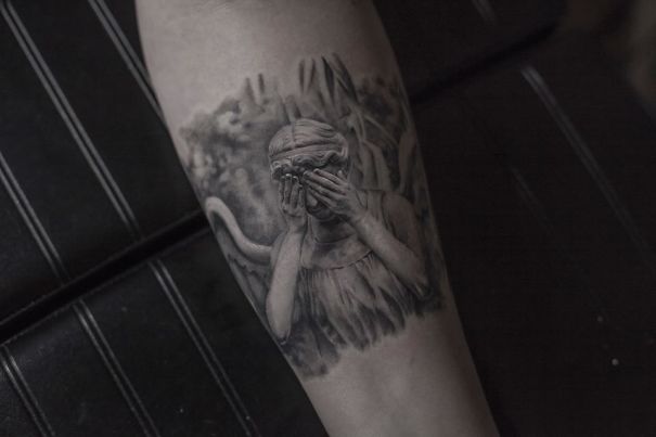 A realistic tattoo of an angel on a person's leg, crafted by a Belgian tattooist.